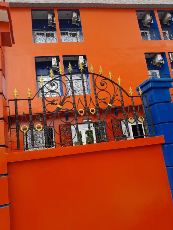 ein orangefarbenes Gebäude mit einem Balkon mit Fenstern in der Unterkunft Marilyn hotel 