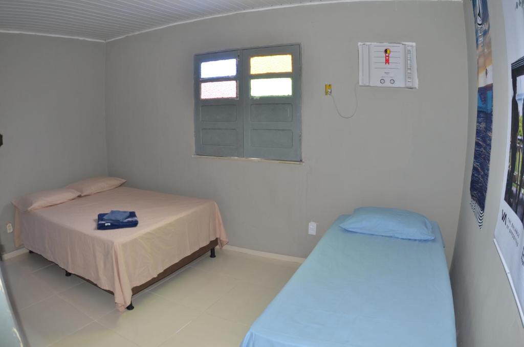 a small room with a bed and a window at Suítes good trip Itacare sem estacionamento in Itacaré