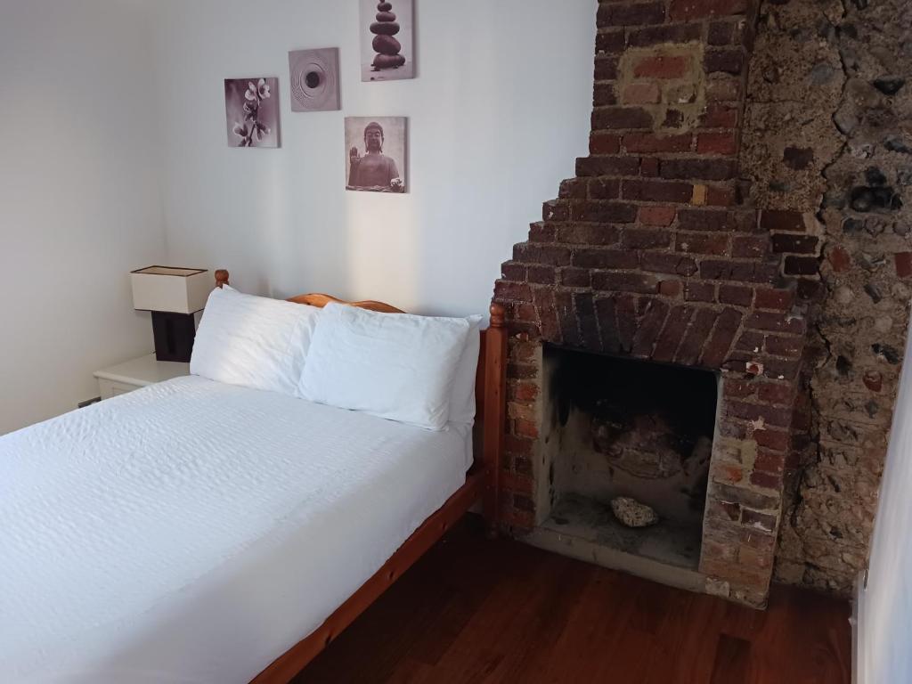 a bedroom with a bed and a brick fireplace at Number Three in Brighton & Hove