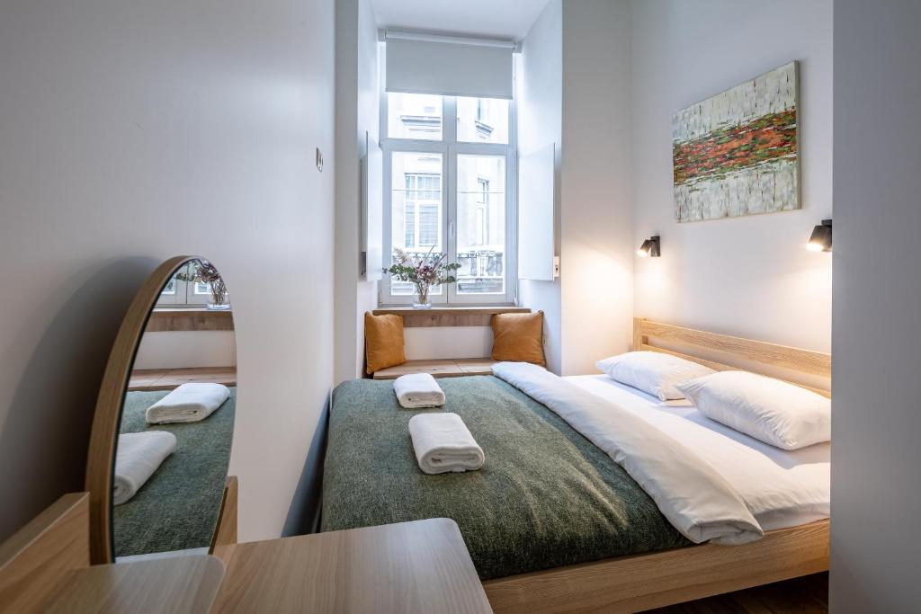 a bedroom with a large bed and a mirror at Apartments on Krakowska street in Lviv