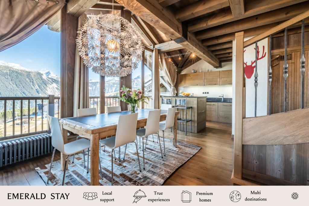 a dining room with a table and chairs and a chandelier at Apartment Tiama Courchevel 1850 - by EMERALD STAY in Courchevel