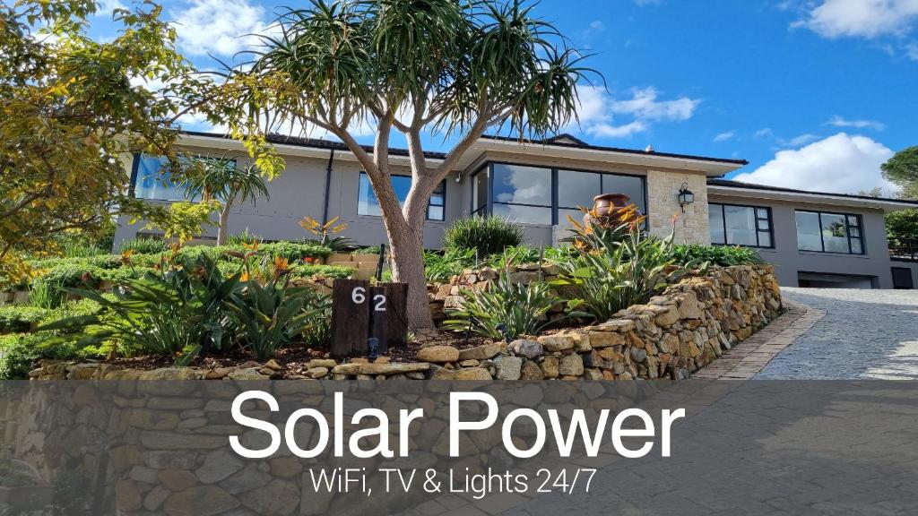 a house with a solar power sign in front of it at Vrede Self Catering in Somerset West