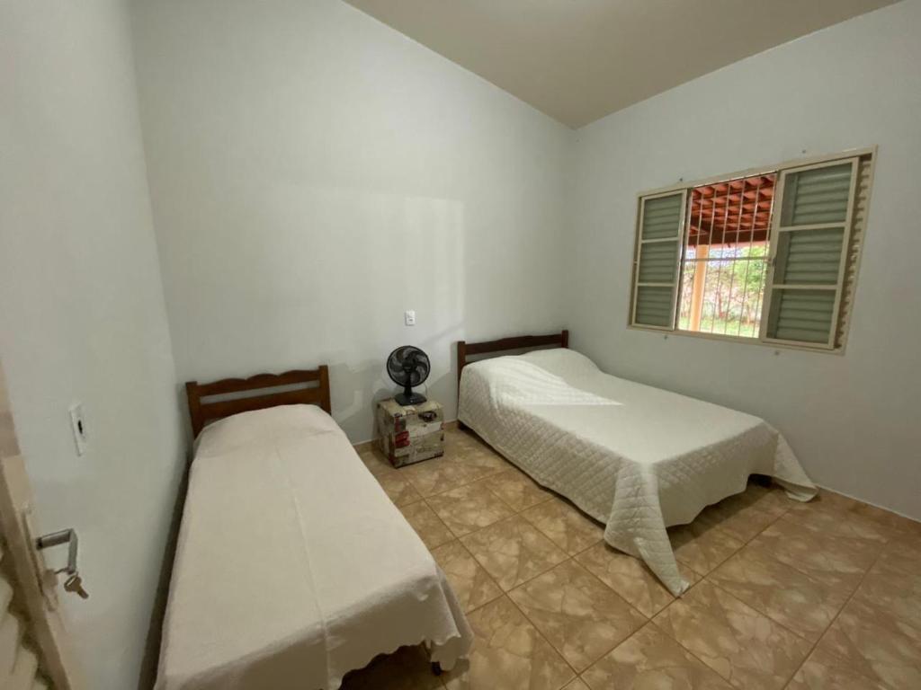 a bedroom with two beds and a window at Jardim Canastra in São Roque de Minas