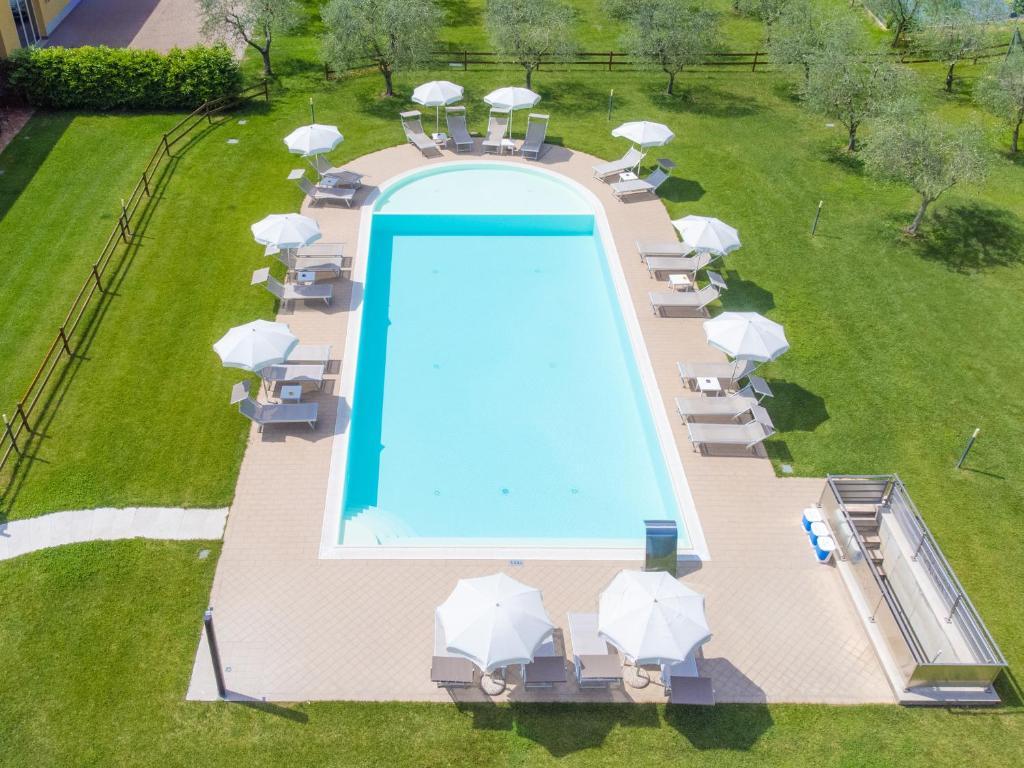 una vista aérea de una piscina con sombrillas blancas en Agriturismo Ai Prati, en Lazise