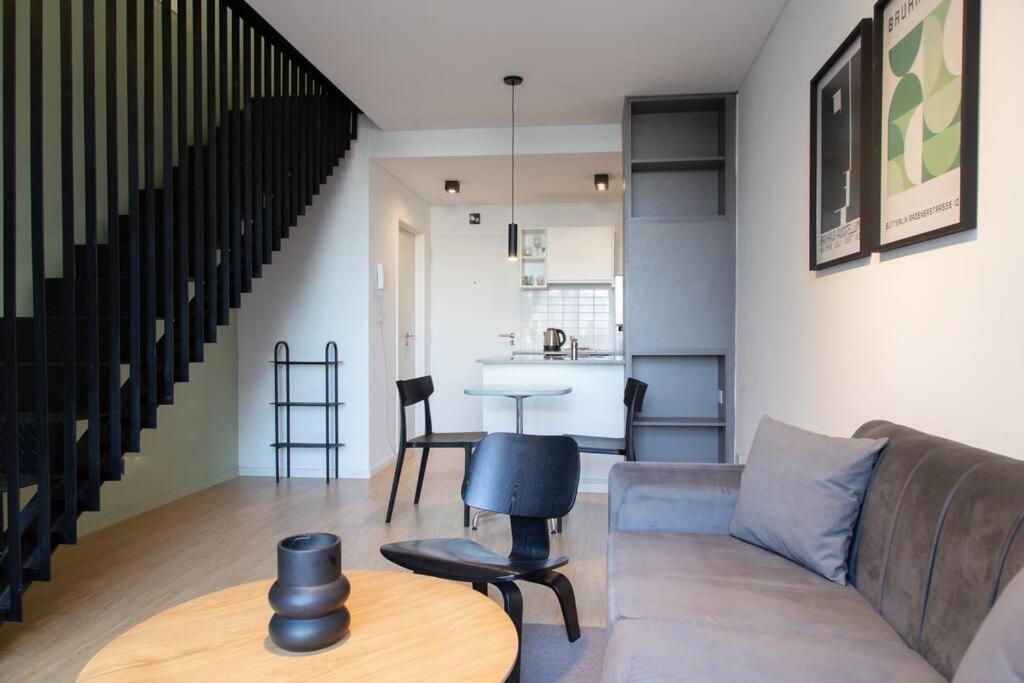 - un salon avec un canapé et une table dans l'établissement Olmo Deluxe Loft Apartment, à Buenos Aires
