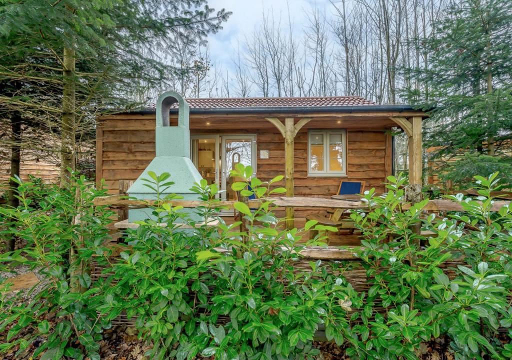 a small wooden cabin with a large door at Squirrel in Postling