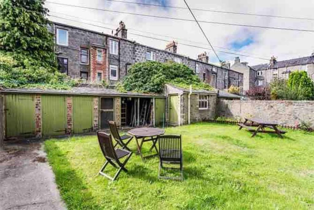 a backyard with a table and chairs in a yard at Stunning 1-Bed Apartment in Aberdeen city centre in Aberdeen