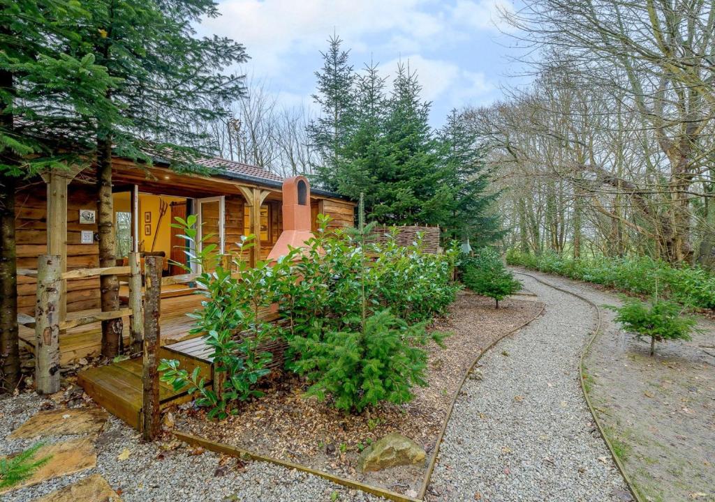 a cabin in the woods with a path leading to it at Badger in Postling