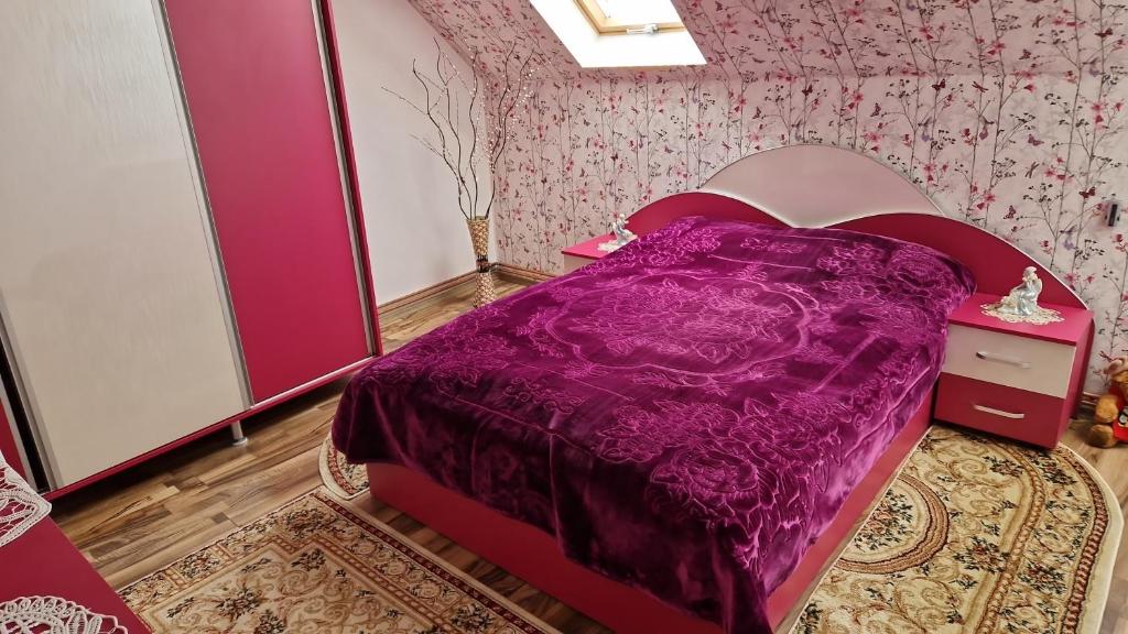 una camera con letto viola di Casa Tru a Zărneşti
