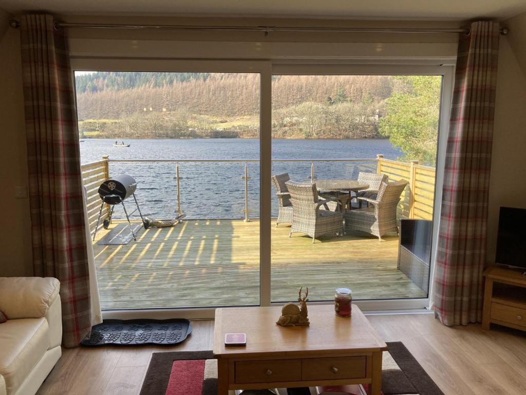 a living room with a view of a large glass door at Lodge 24 in Spean Bridge
