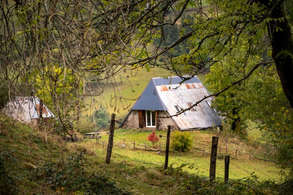 una vieja casa en una colina en un campo en Le Pradima en Mandailles