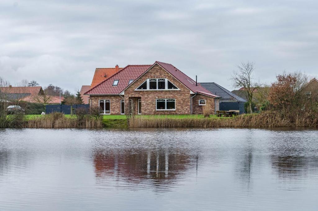a house sitting next to a large body of water at Haus mit Seeblick in Nenndorf