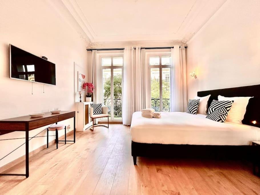 une chambre avec un lit et un bureau dans une pièce dans l'établissement Charme et Volupté à République, à Paris