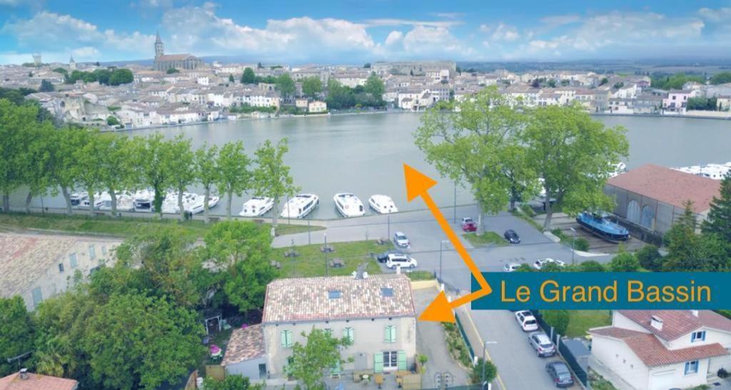 an aerial view of a street with a lake and a city at Le Grand Bassin in Castelnaudary