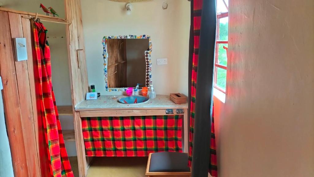 a bathroom with a sink and a mirror at Beats Of Beads Trust in Masai Mara