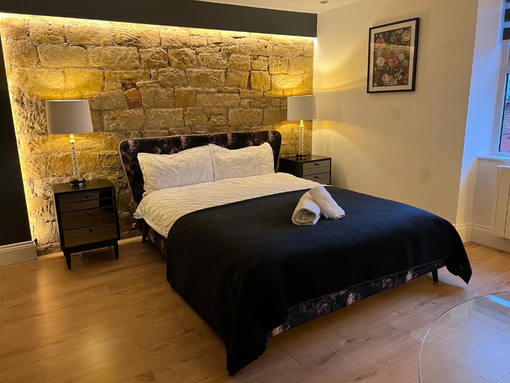 una camera con letto e muro di mattoni di Luxury Grand Studio Apartment @3 a Barnsley