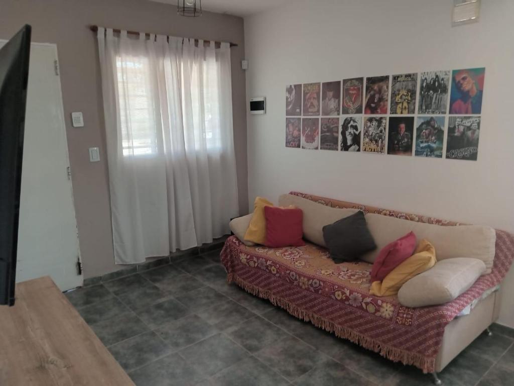 a living room with a couch with pillows on it at La Casita de Nala in Neuquén