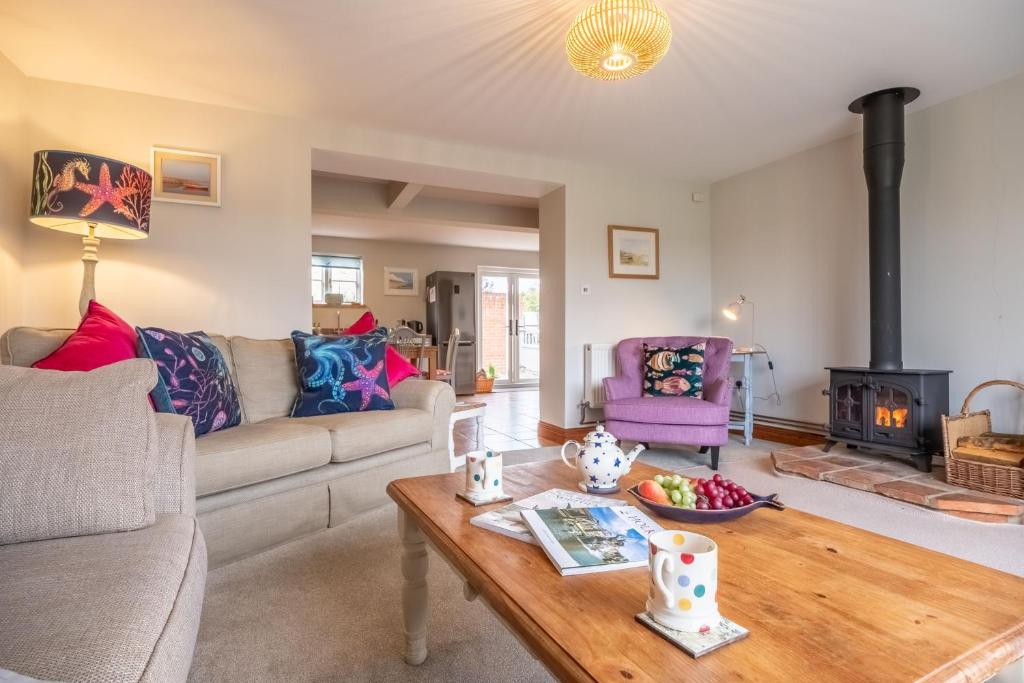 a living room with a couch and a table at Cornloft Cottage in South Creake