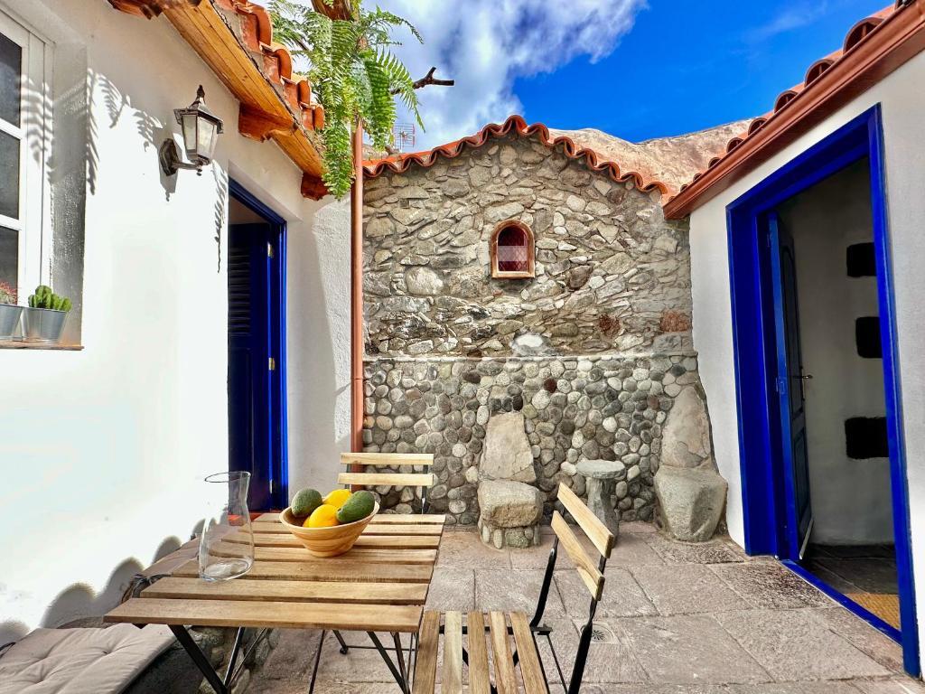 een tafel en stoelen op een patio met een stenen muur bij Teresitas Beach Escape Apartment in San Andrés
