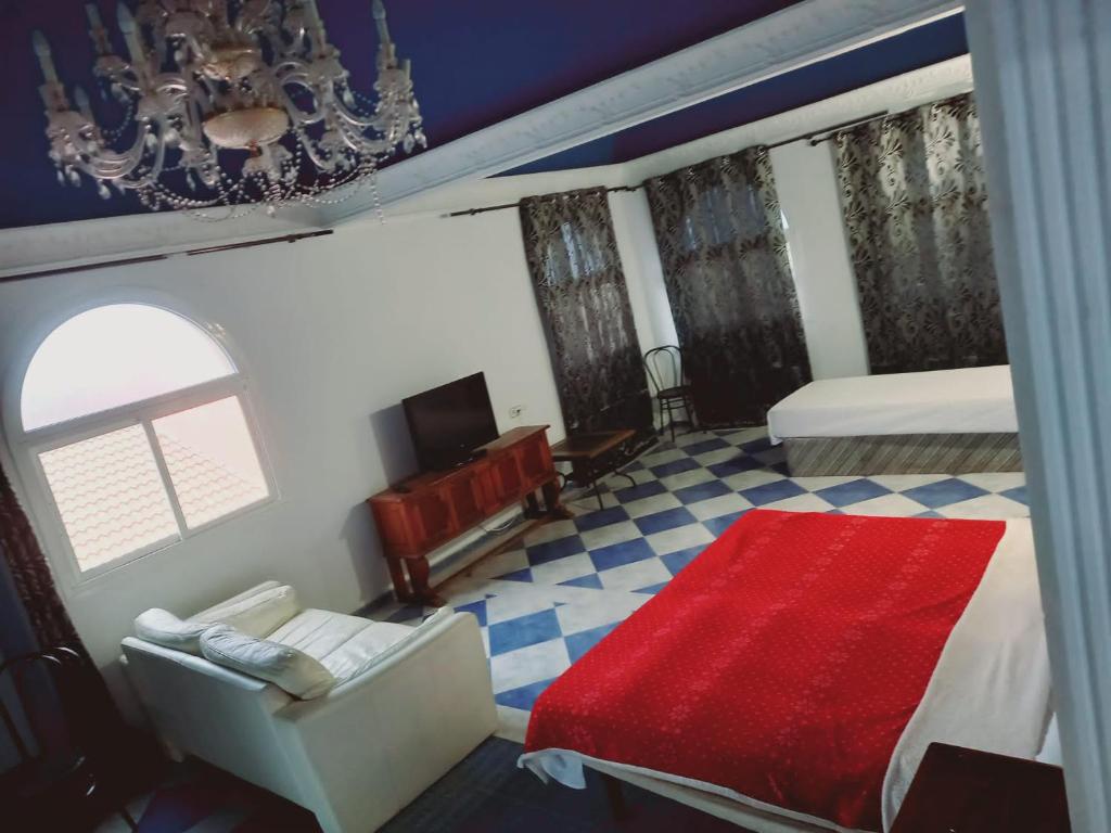 1 dormitorio con 1 cama, 1 silla y 1 alfombra roja en Lounge estrella en Benalmádena