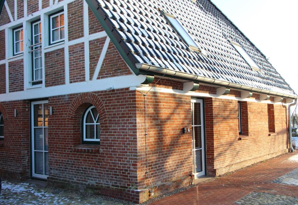 a red brick building with a pitched roof at Ferienwohnung Emma in Jork