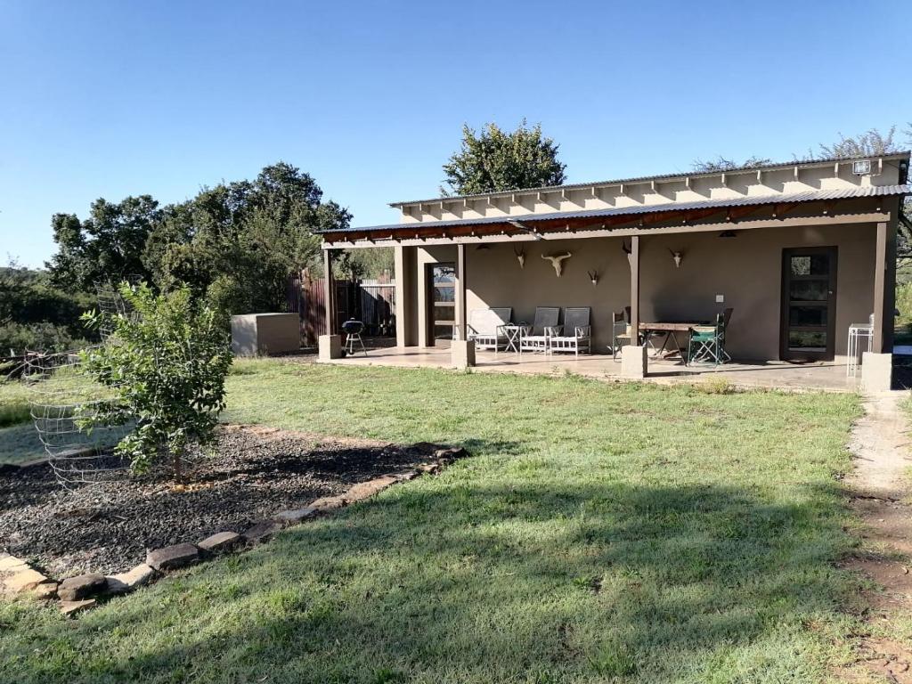 ein Haus mit einer Terrasse und einem Hof in der Unterkunft Bundu Camp in Heilbron