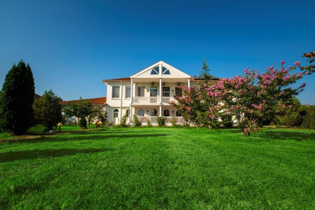 a house with a large yard with green grass at Casa di Bakalovi in Burgas City