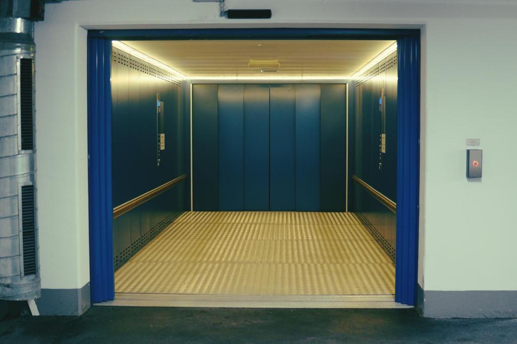 an elevator with blue doors in a building at Domus Hotel in Luxembourg