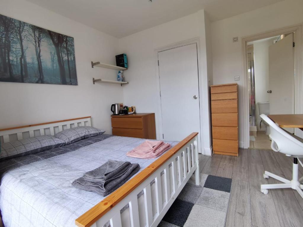 sypialnia z białym łóżkiem i umywalką w obiekcie Double bedroom with bathroom en suite and a large balcony for short or long let in London Canary Wharf E14 w Londynie