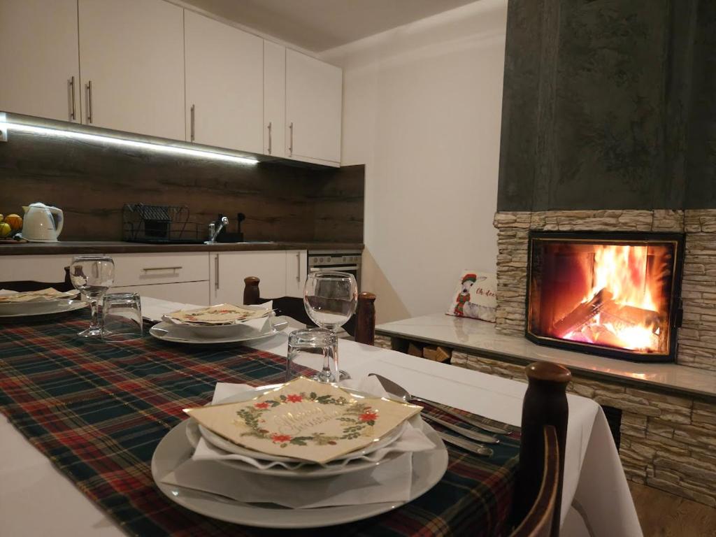 cocina con mesa de comedor y chimenea en Planinska kuća Ruža en Kupres