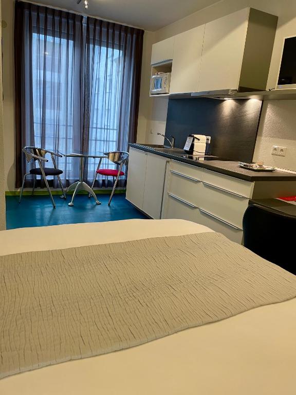 a room with a kitchen with a table and chairs at Domus Hotel in Luxembourg