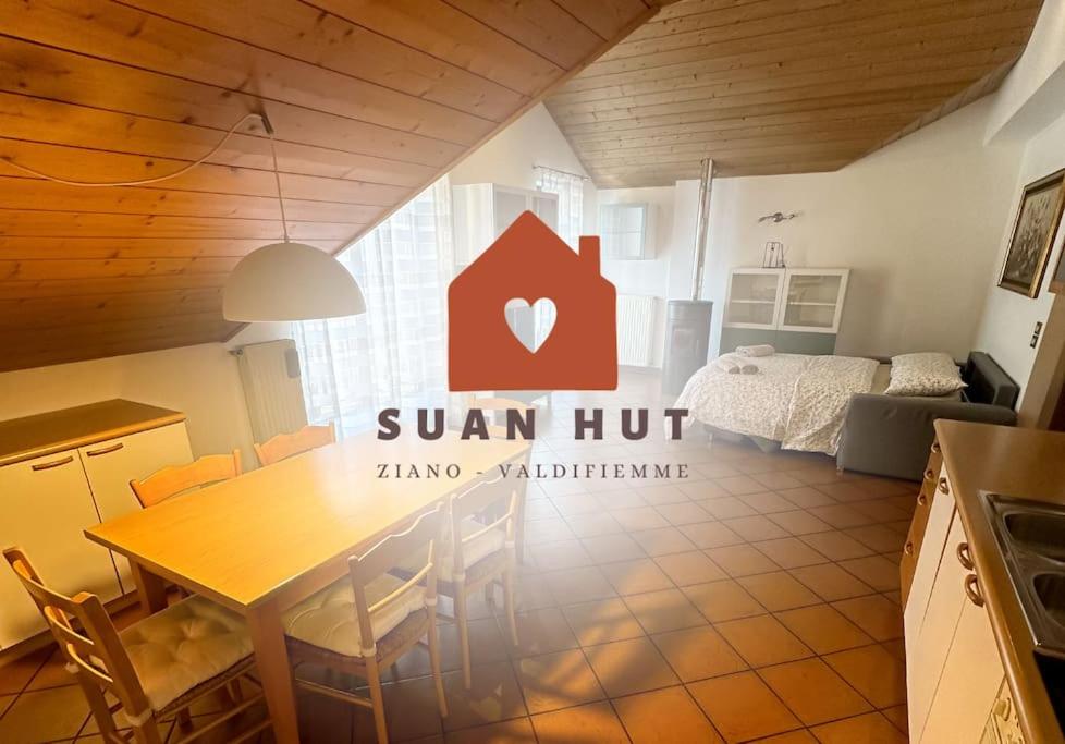 a kitchen with a table in a room with a bed at Suan Hut in Ziano di Fiemme