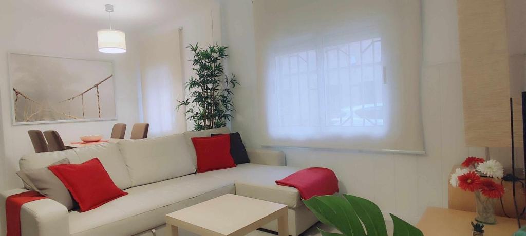 ein Wohnzimmer mit einem weißen Sofa und roten Kissen in der Unterkunft Maria House in Viladecáns