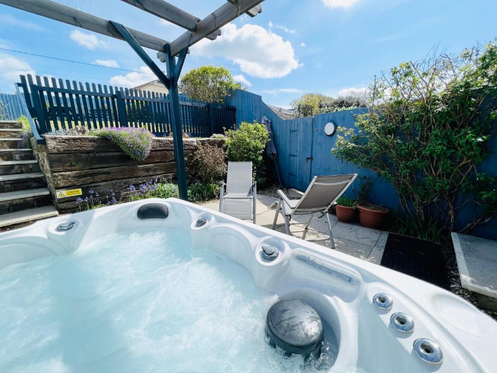 a jacuzzi tub in a backyard with a fence at Lundy Lookout 5 minutes drive to beach Hot tub in Westward Ho
