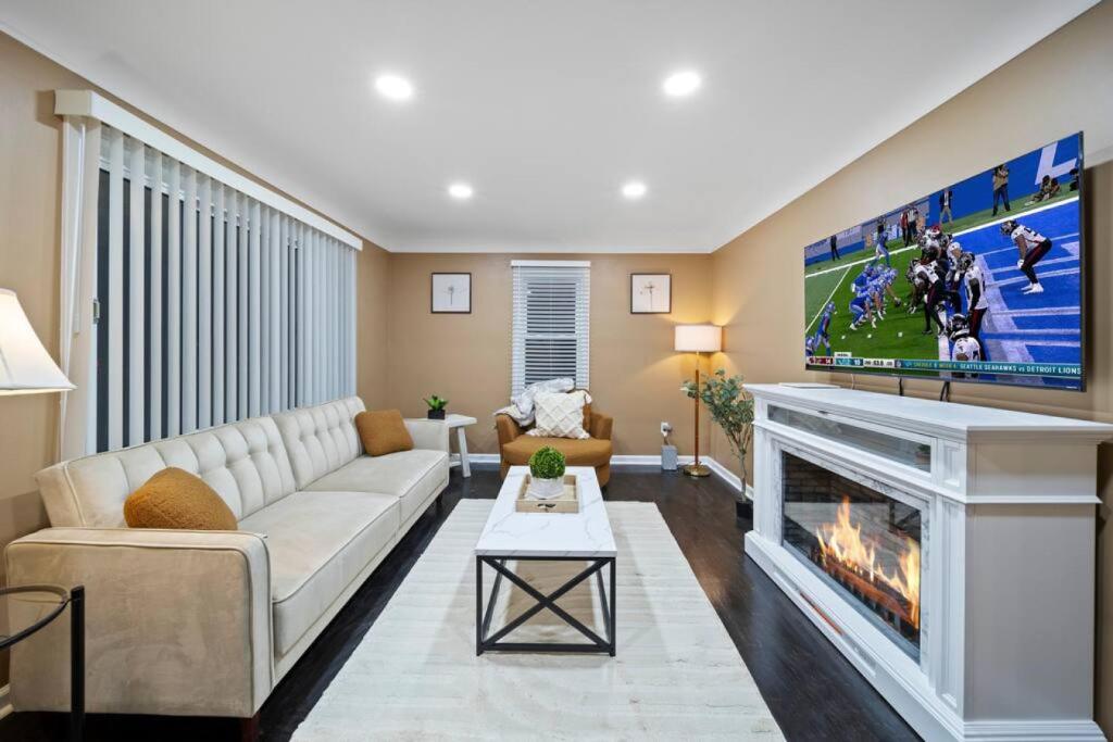 a living room with a couch and a fireplace at Elegant Oasis 4 Bedroom Home Away from Home in Utica
