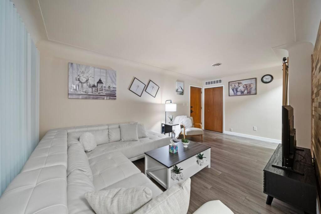 un salon avec un canapé blanc et une télévision dans l'établissement Modern Cozy 1 Bedroom Apartment in Shelby Township, à Shelby