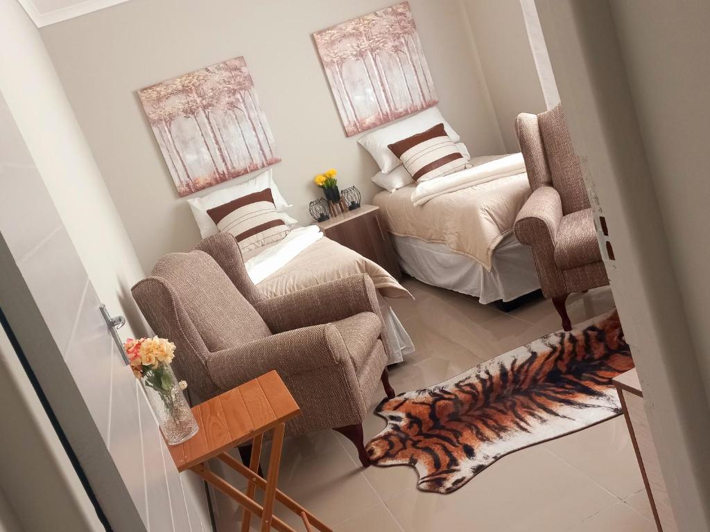 a living room with two beds and a chair at TALITHA'S SELF-CATERING ACCOMONDATION in Walvis Bay
