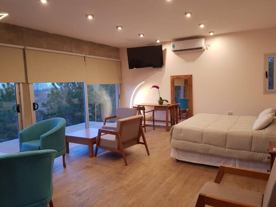 een slaapkamer met een bed en een tafel met stoelen bij Cabaña La Reserva Suite in La Granja