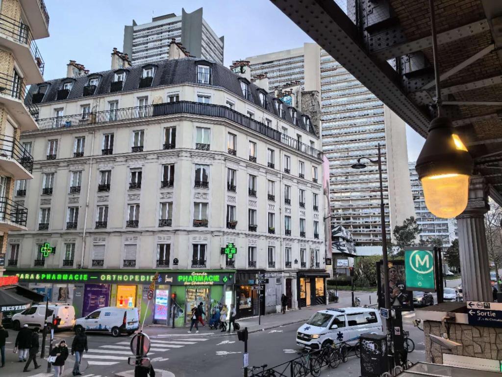 - un grand bâtiment blanc dans une rue animée de la ville dans l'établissement Chevaleret-Paris, à Paris