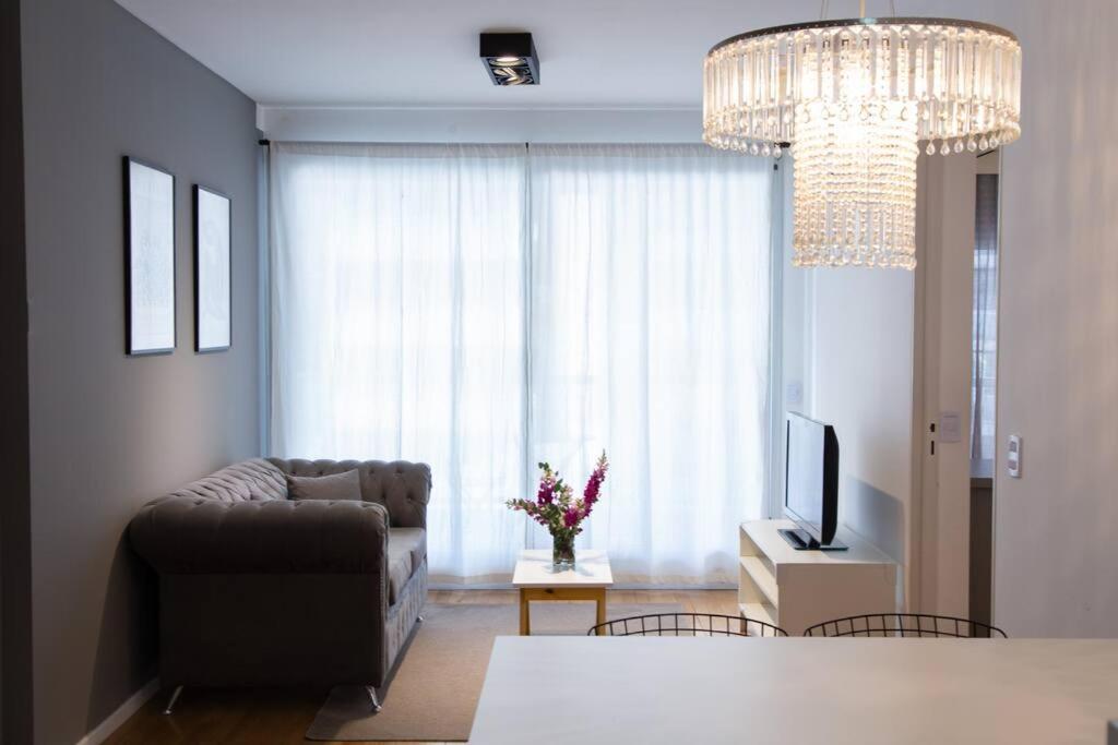 uma sala de estar com um sofá e uma televisão em Abedul Deluxe Apartment em Buenos Aires