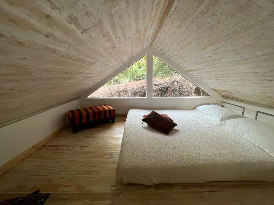 a bedroom with a large bed with a large window at Eco-Chic Retreat: Countryside Oasis Near Florence in Pozzolatico