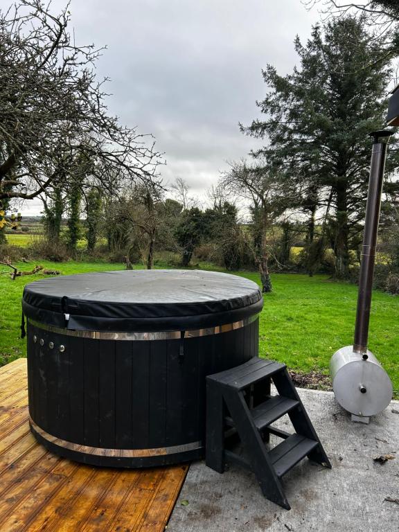 um grande barril preto com um banco num deque de madeira em Lemonade Cottages and Retreat em Kilrush