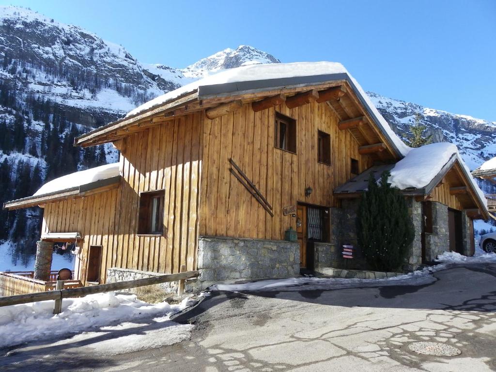 a large wooden building with a clock on it at CHALET ALISTELLE - 10 à 12 personnes - TIGNES LES BREVIERES in Tignes