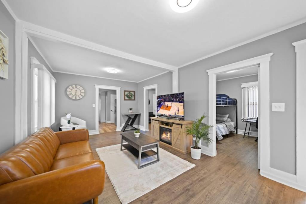uma sala de estar com um sofá e uma televisão em Stylish Luxury 3bd home in Down Town Royal Oak em Royal Oak
