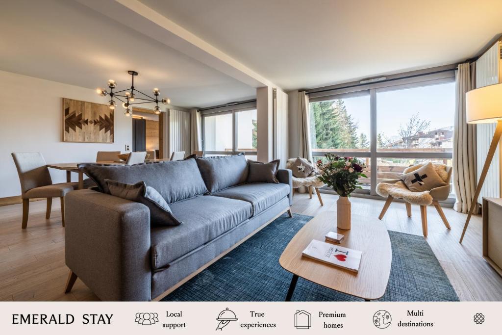 uma sala de estar com um sofá e uma mesa em Apartment Cortirion Megeve - by EMERALD STAY em Megève