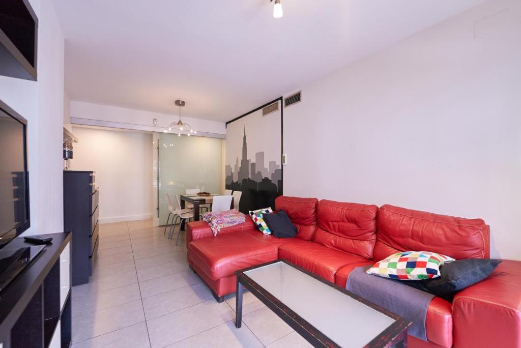 a living room with a red couch and a table at Vivir en el Campus de la Salud in Granada