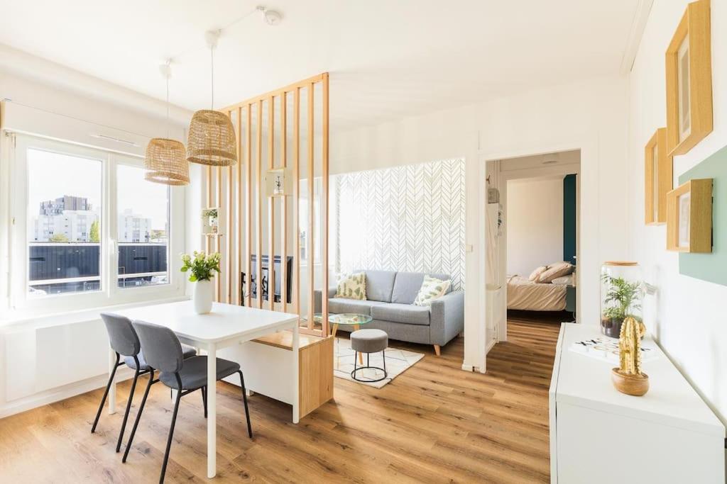 un salon avec une table, des chaises et un canapé dans l'établissement La Clef - appartement proche centre et gare, à Saint-Brieuc