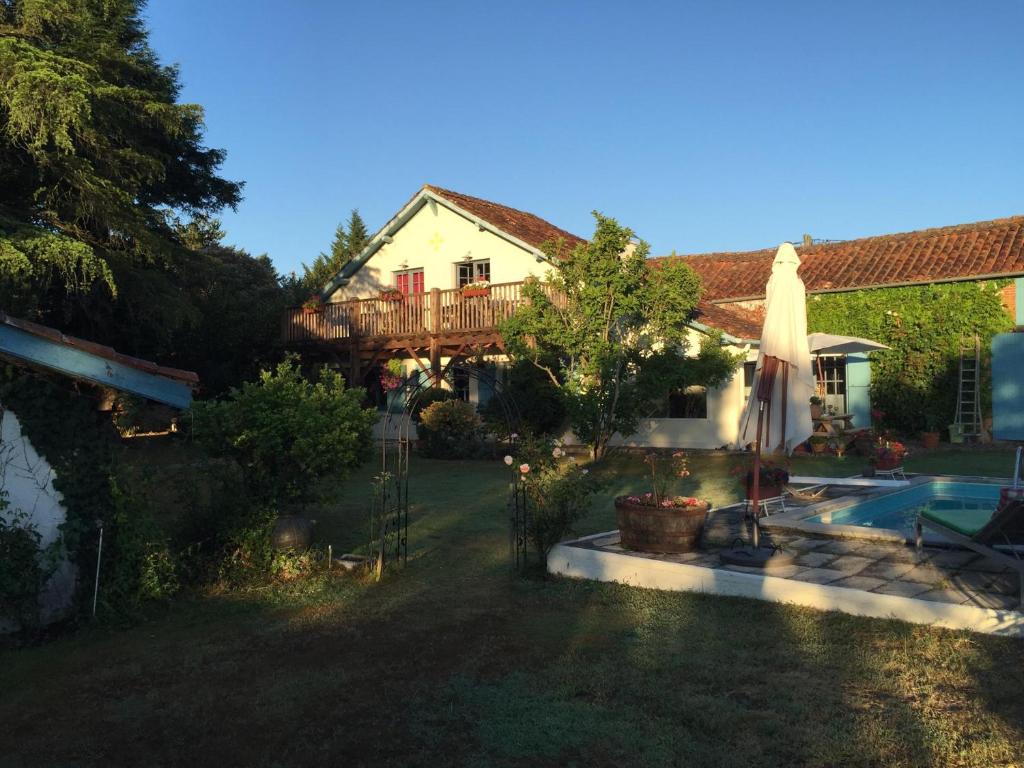 ein Haus mit einem Garten mit Pool und Sonnenschirm in der Unterkunft Immaculate 6 plus Bed Villa with pool in Sarron in Sarron