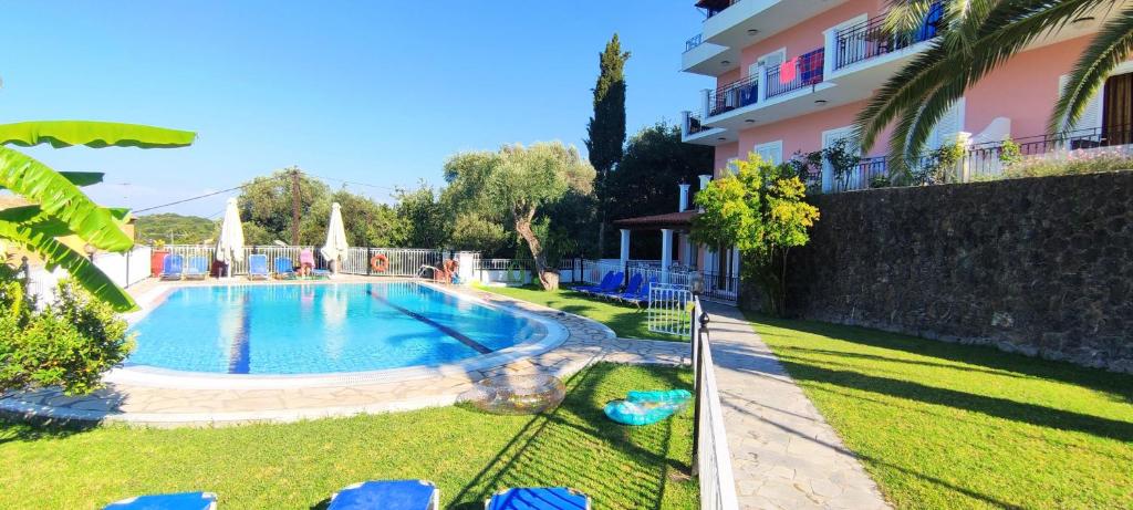 a swimming pool in a yard next to a building at Thomas Apartments in Dassia