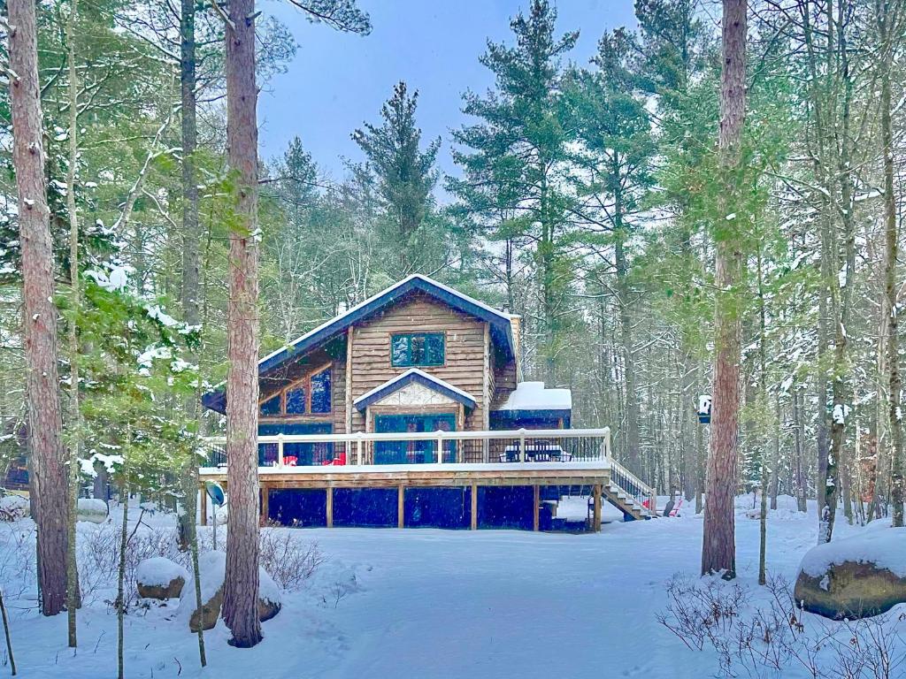 a log cabin in the woods in the snow at ADK Cabin with Hot Tub, Near Whiteface, Lake Placid, Fire Pit, Game Rm in Jay